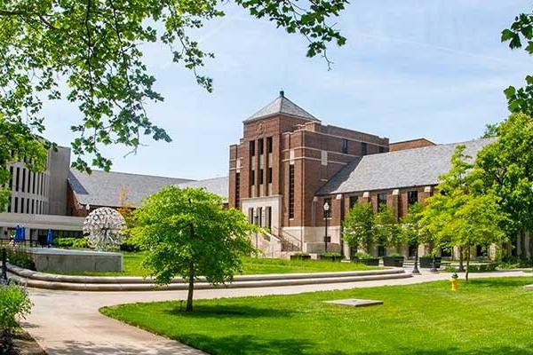 An image of Tirey Hall from across the quad during summer. Parsons Hall and the Trumpets artwork are also visible in the distance.